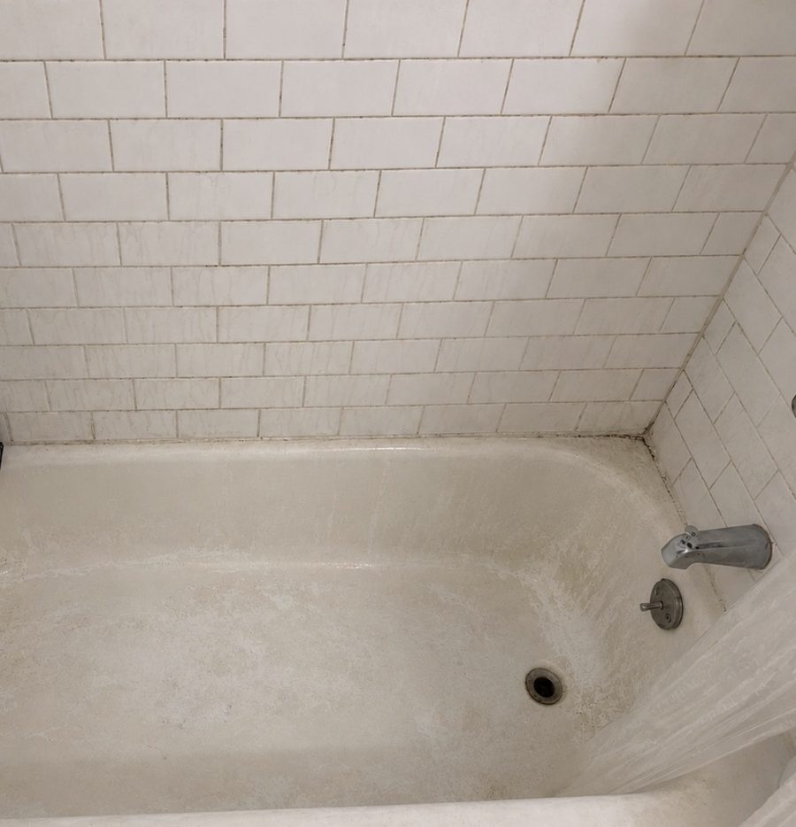 Bathtub and tile before Ivybrook cleaning, with soap scum and grime